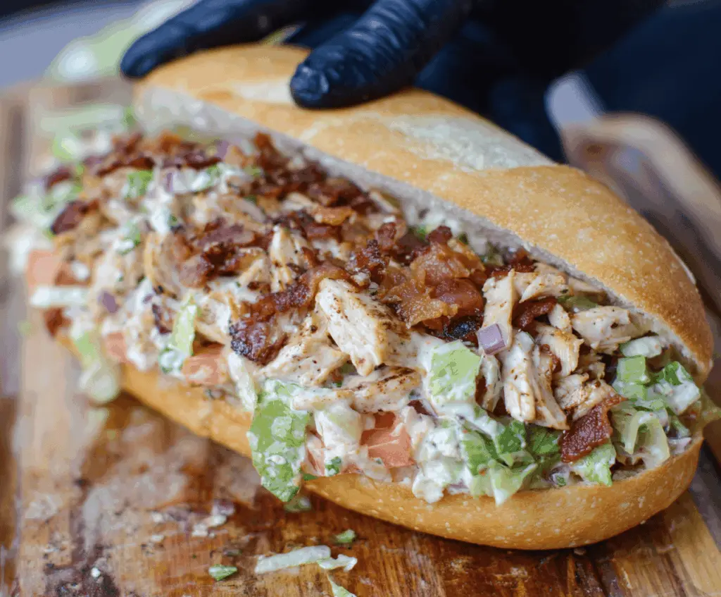 Delicious chopped chicken bacon ranch sandwich with crispy bacon, fresh lettuce, and creamy ranch dressing on a toasted bun