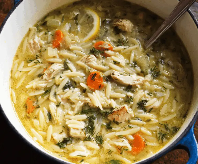 A bowl of Lemon Chicken Orzo Soup garnished with fresh herbs, featuring tender chicken, orzo pasta, and vibrant lemon slices for a flavorful, comforting meal.