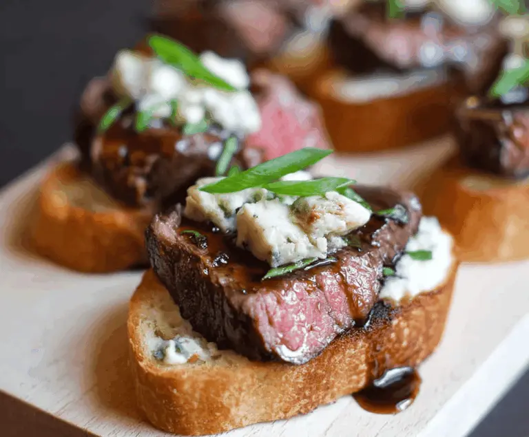 Delicious Beef Tenderloin Gorgonzola Crostini with melted cheese and fresh herbs on toasted baguette slices