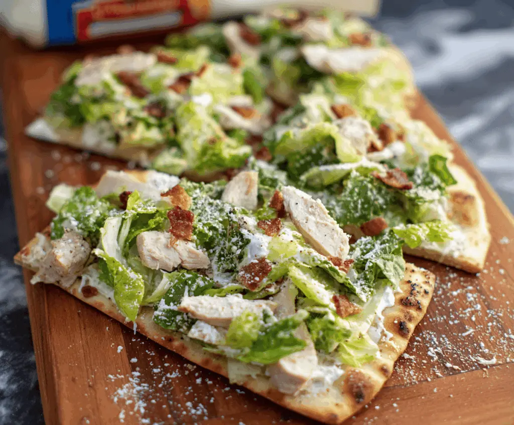 Delicious Chicken Caesar Flatbread topped with grilled chicken, romaine lettuce, and Caesar dressing.