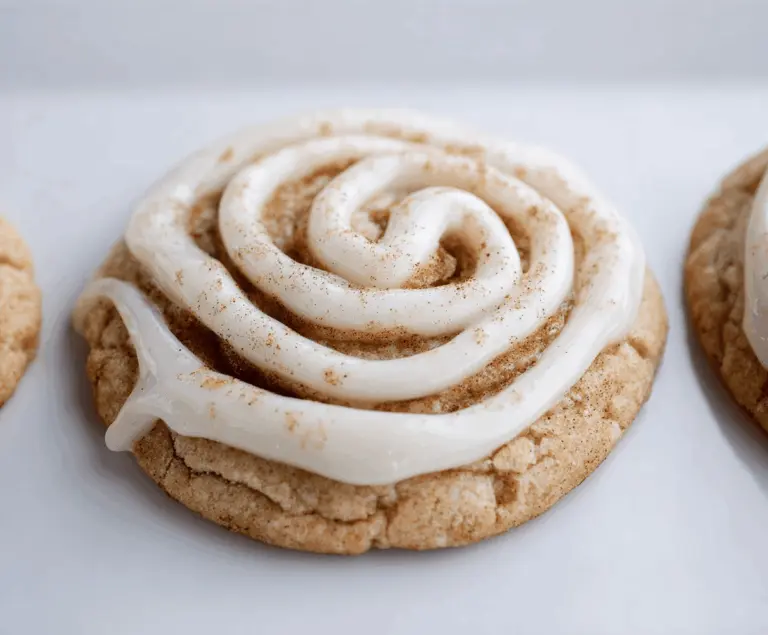 Delicious cinnamon roll cookie with swirled icing on top, perfect for sweet cravings.