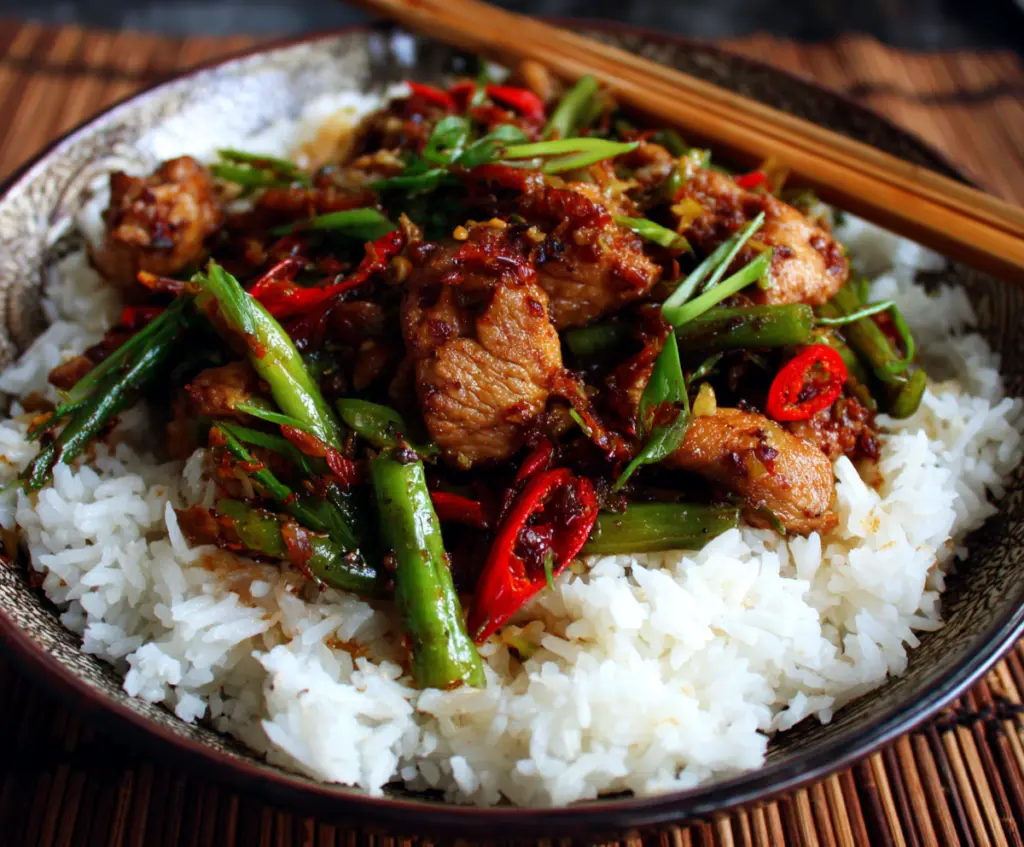 Delicious stir-fried Chinese garlic chicken served on a plate garnished with green onions