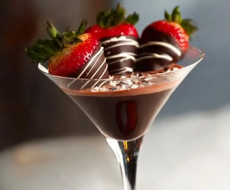 Elegant Chocolate Covered Strawberry Martini garnished with fresh strawberries and chocolate drizzle.