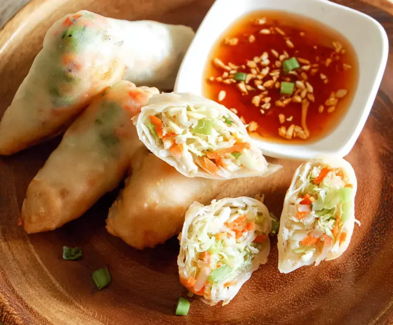 Fresh Thai spring rolls filled with vegetables and herbs, served with a dipping sauce.