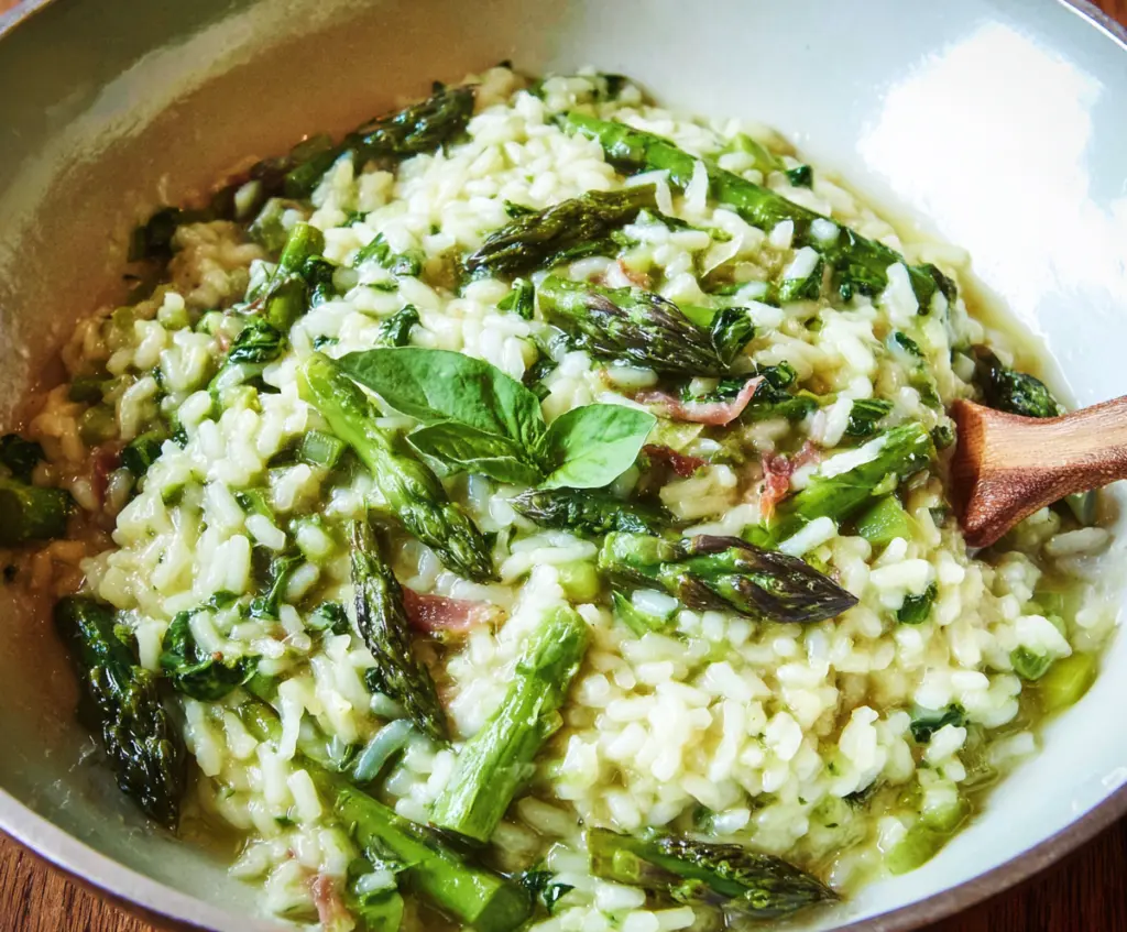 Creamy asparagus risotto garnished with fresh herbs and grated cheese on a rustic plate.