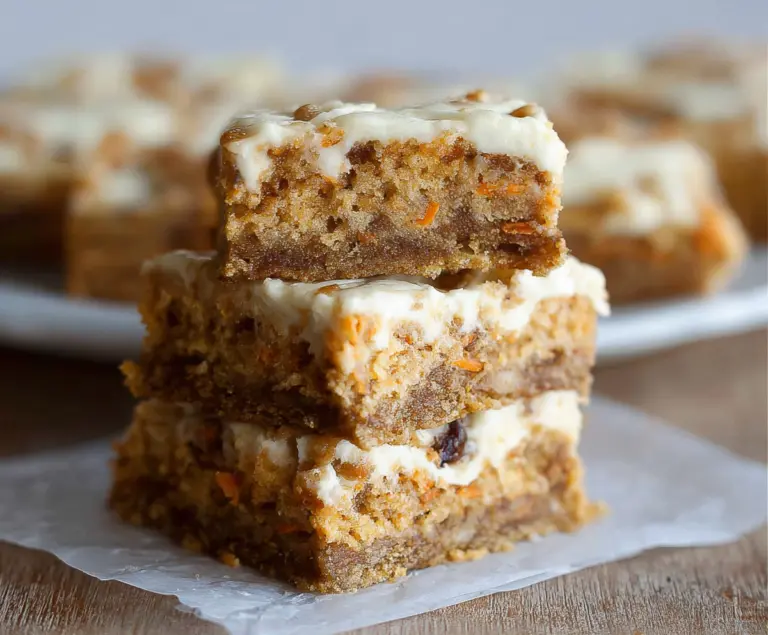 Delicious homemade carrot cake bars with creamy frosting and crunchy walnuts on top.