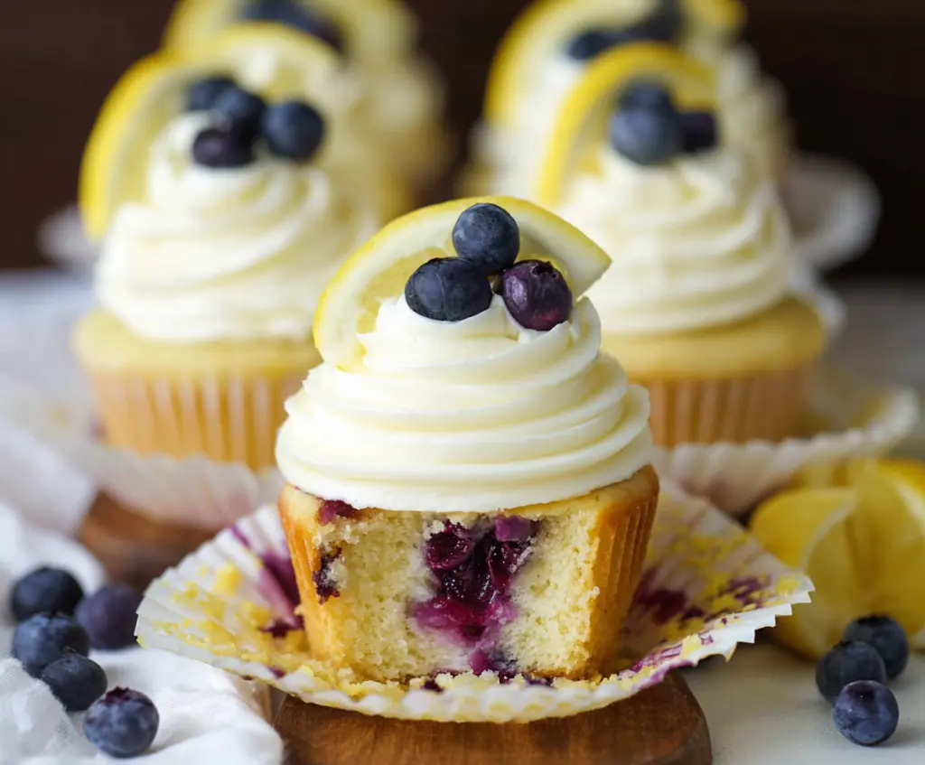Delicious lemon blueberry cupcakes with fresh blueberries and lemon zest on top.