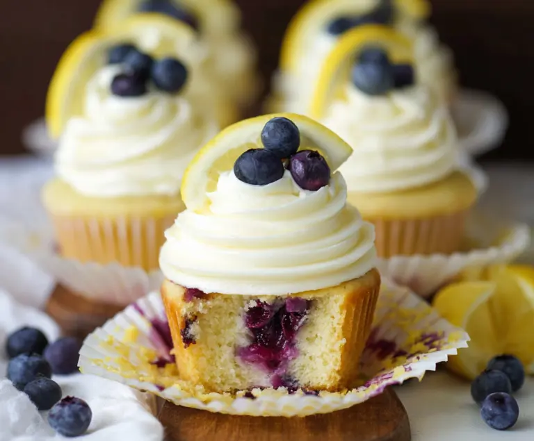 Delicious lemon blueberry cupcakes with fresh blueberries and lemon zest on top.