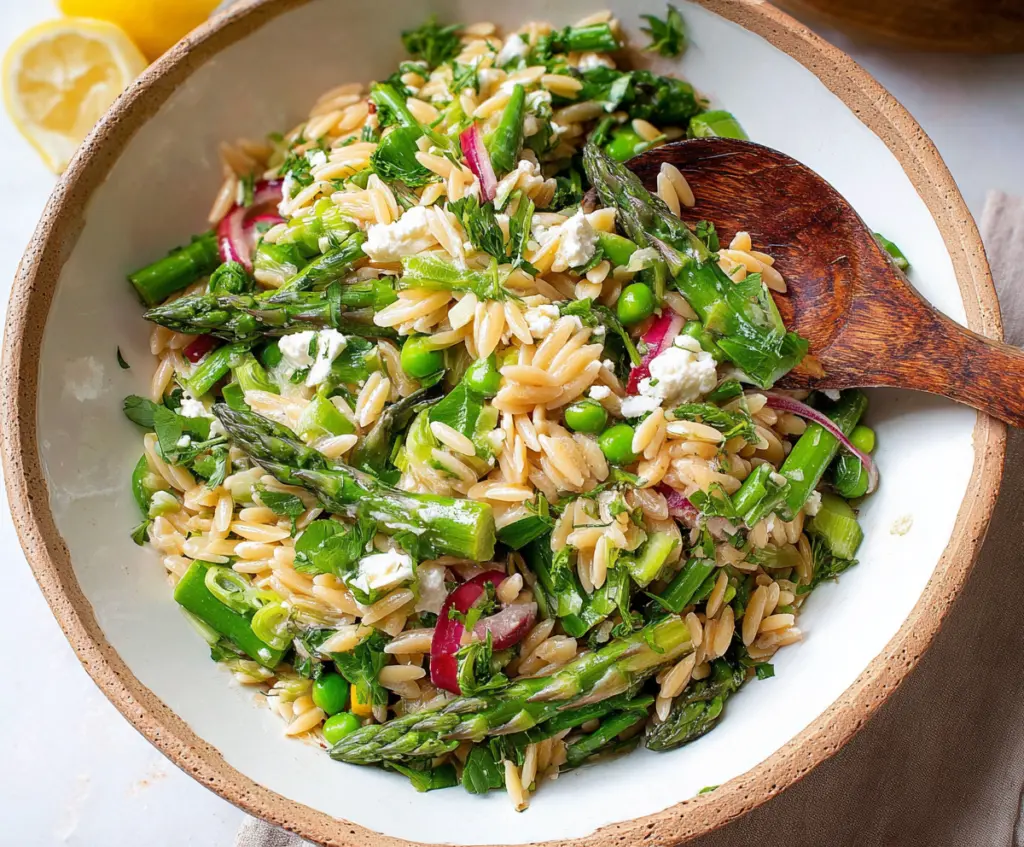 Fresh orzo salad with tender asparagus and cherry tomatoes, perfect for a light summer meal.